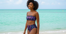 Load image into Gallery viewer, Woman wearing a colorful &#39;Miami&#39; bikini on a beach with turquoise water and sky.
