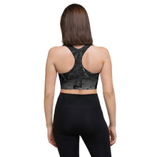 Load image into Gallery viewer, Back of the sports bra. Black and gray with gray swirls on the sports bra, With a silhouette of a woman laying with her leg kicked in the air. 
